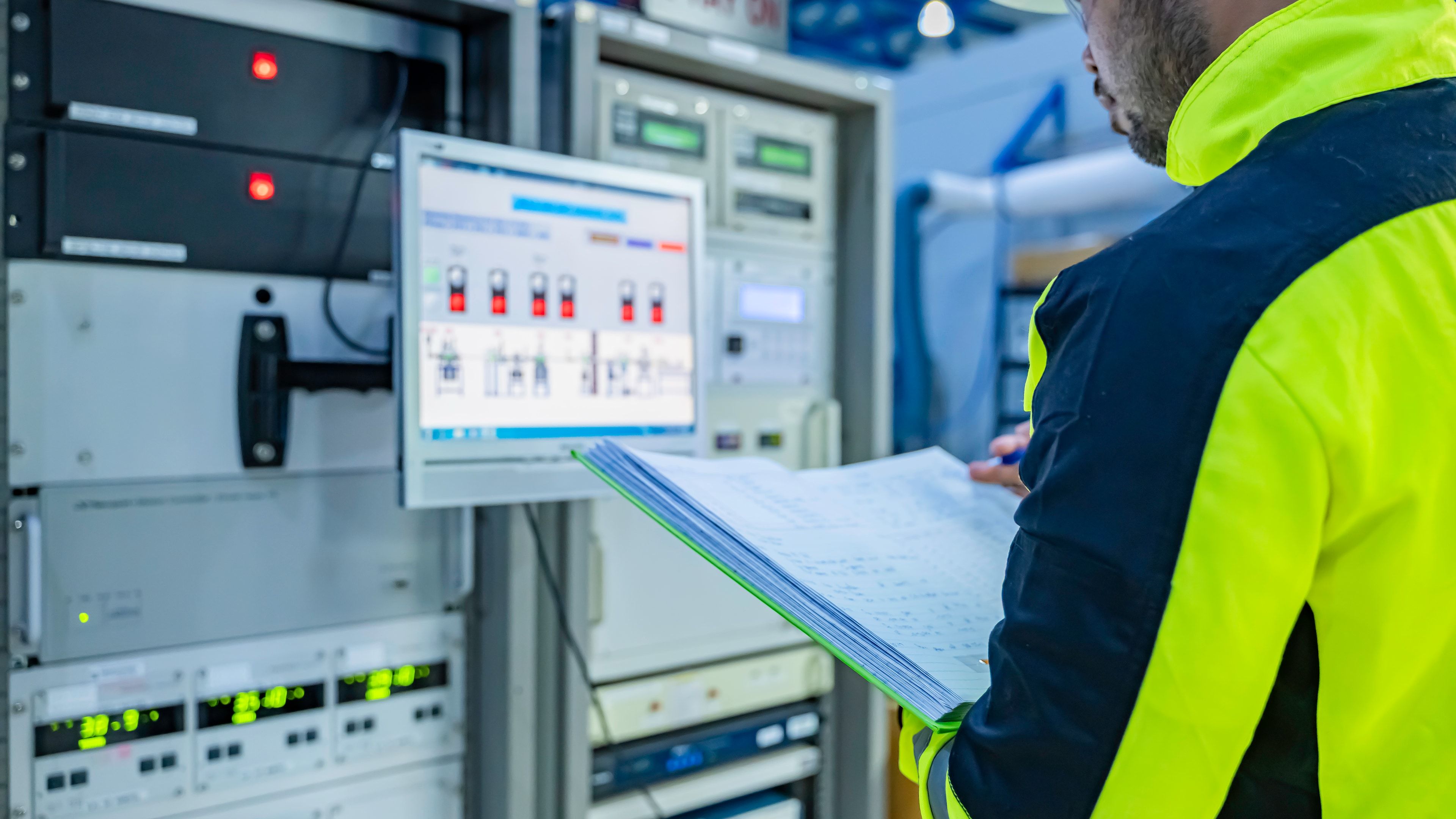 Ingeniera revisando la tensión en un cuadro de distribución eléctrica industrial