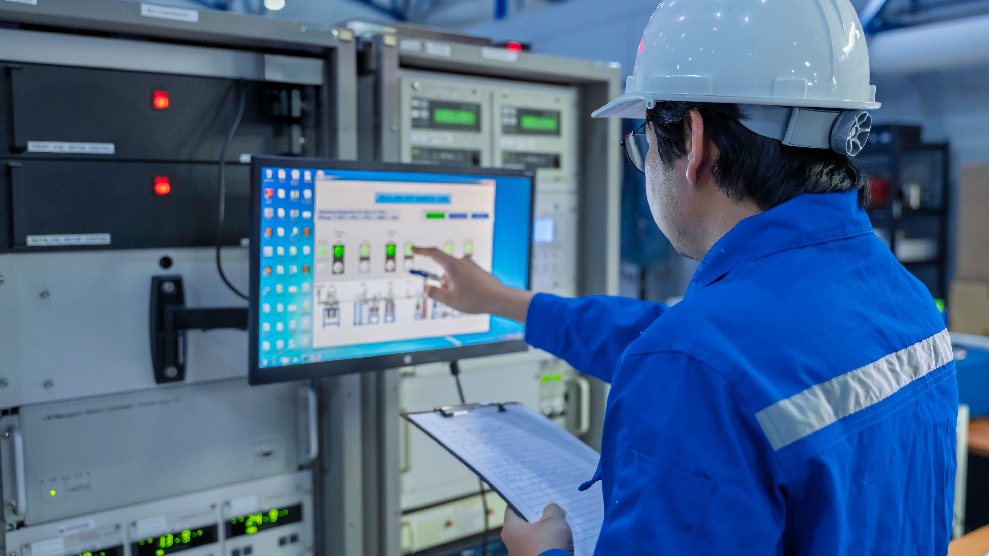 Técnico en la sala de control de una gran planta industrial